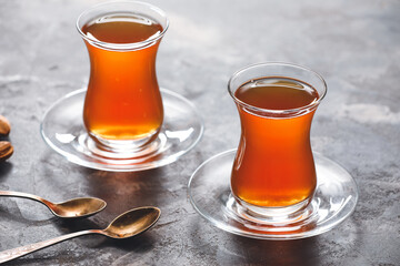 Cups with hot Turkish tea on grey background