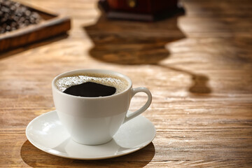 Cup of hot coffee on wooden background