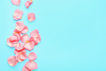 Fototapeta na wymiar Beautiful pink rose petals on color background