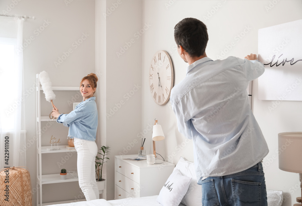 Poster Young couple cleaning their bedroom