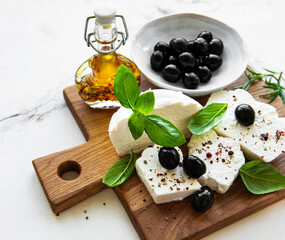 A fresh ricotta with basil leaves and olives