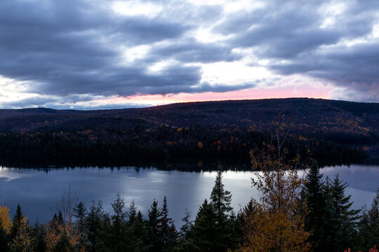 vue d'une sombre rive de l'autre côté d'un lac lors de la fin d'un coucher de soleil © Veronique