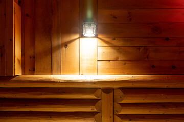 Façade de bois avec lampe installée sur le mur créant un halo chaleureux