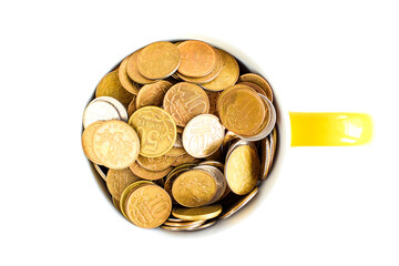 Metal coins in a ceramic cup isolated on a white background. Keeping personal savings. Financial crisis, devaluation of the ruble. Selective focus. Copy space for text.