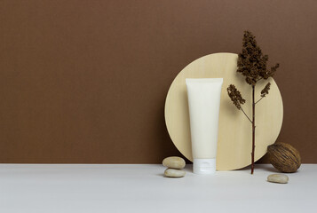 Cosmetic cream in a tube on a brown background. Natural cosmetics. Skincare. Mock-up. Copy space.
