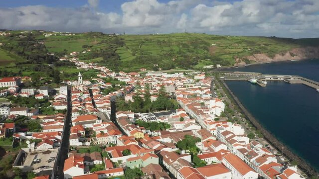 Drone shot of Porto Pim Bay and Horta city, Faial Island, Azores, Portugal, Europe. Aerial view of traditional small houses and embankment of Horta at atlantic ocean, 4k footage