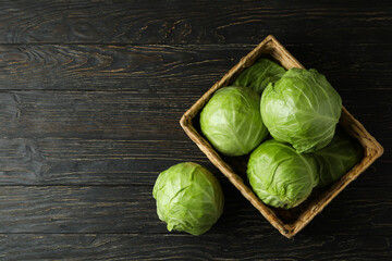Basket with fresh cabbage on wooden table