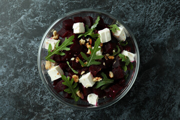 Bowl with fresh beet salad on black smoky background