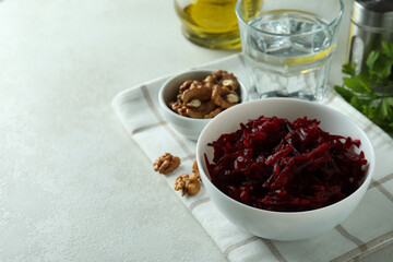Concept of tasty eating with bowl of beet salad on white textured table