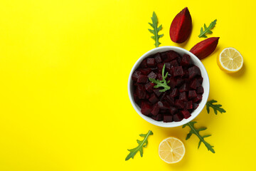 Fresh beet salad and ingredients on yellow background, top view