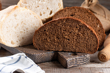 Loaf of bread and rye bread still life on wooden background