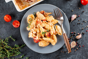 Trending viral recipe of baked tomatoes and feta with pasta. Fetapasta on a dark background. Copy space. Top view.