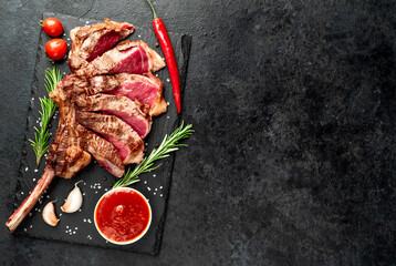 tomahawk beef steak grilled with spices on stone background with copy space for your text