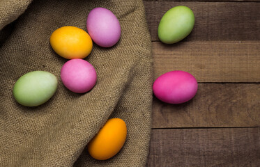 beautiful easter eggs on burlap, on a rustic background flat lay