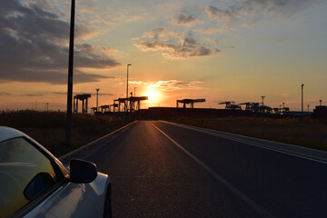 夕焼けコンテナと車の窓とドアミラーそして地図にまだ無い道