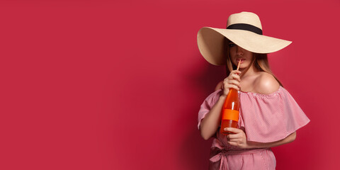 Lovely woman in dress and straw hat with cold drink
