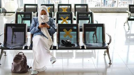 Asian women are tired of waiting at the station wearing jilbab and analog camera