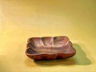 brown wooden bowls lie on the yellow background - obrazy, fototapety, plakaty
