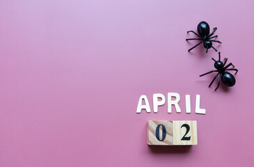 Day 2 of April month, Wooden calendar with date and plastic ants.