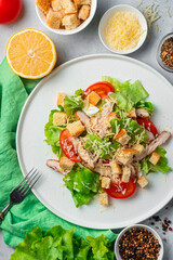 Fresh Caesar salad and ingredients on a gray background. Colorful photo, top view. Vertical orientation.
