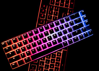 top view of two illuminated RGB keyboards in the dark