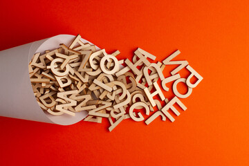 wooden alphabet letter spilled from a paper cone