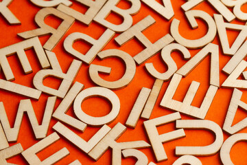 wooden cut alphabet letters on orange background