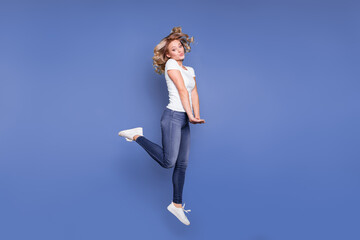 Obraz premium Full body profile side photo of young girl happy positive smile have fun jump up isolated over blue color background