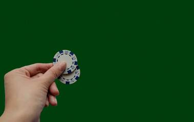 casino chips in hand on green background