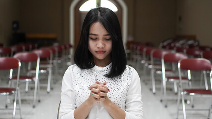 a Christian woman praying humbly in church