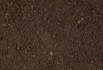 Background with brown dry soil. Pitchfork on top.