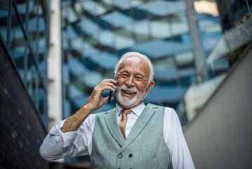 Senior business man talking on smart phone. Man in city.
