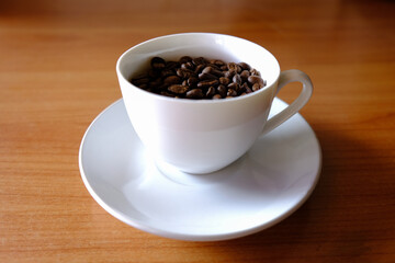 coffee beans in cup coffee on table wood background