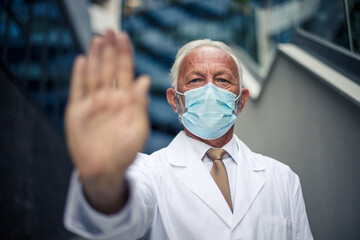 Senior doctor standing on street