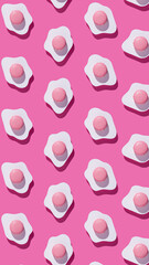 Fried eggs pattern made of paper on a vibrant pink background. Minimalistic food fashion pop art concept. Flat lay, top view.