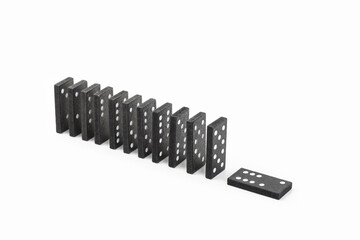 Fichas de dominó negras en fila sobre un fondo blanco liso y aislado. Vista superior y vista de frente. Copy space
