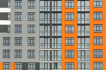 The facade of a multi-storey building with windows and balconies as an element of the architecture of a modern city