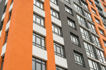 The facade of a multi-storey building with windows and balconies as an element of the architecture of a modern city
