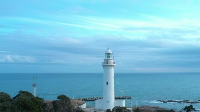 Rotating drone shot of a lighthouse by the ocean in Iwaki Japan.