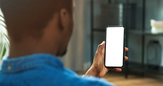 Close up of African American man holding new black smartphone with blank screen in hands. Mobile phone with blank copy space screen for your text
