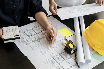 The architect was pressing the white calculator and there was an engineer standing there holding...