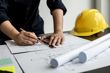 An architect, a home design engineer, is drafting a house plan for a client in his office. He is writing a house plan based on the needs of his clients. House building and interior ideas.