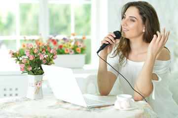 Beautiful young woman singing karaoke