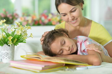 Obraz premium little girl fell asleep while doing homework