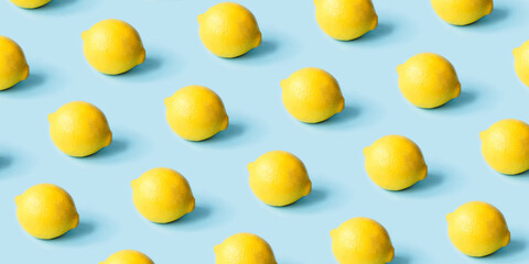 Pattern of ripe lemons on a blue background. Summer concept.