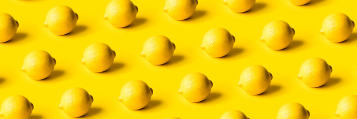 Pattern of ripe lemons on a yellow background. Summer concept.