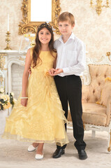 Beautiful  girl  in yellow  dress and boy  posing in the room