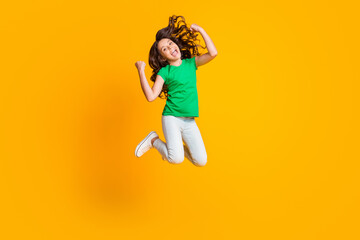 Full size photo of happy screaming excited crazy little girl jumping in victory success isolated on yellow color background