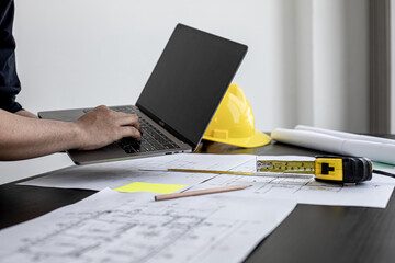 Professional home designers architects are reviewing the laptop house designs sketched in the...