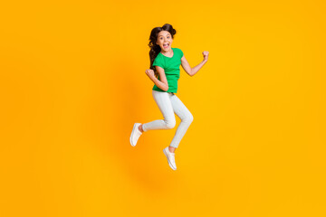 Fototapeta na wymiar Full size photo of happy excited smiling crazy girl jumping in victory success triumph isolated on yellow color background
